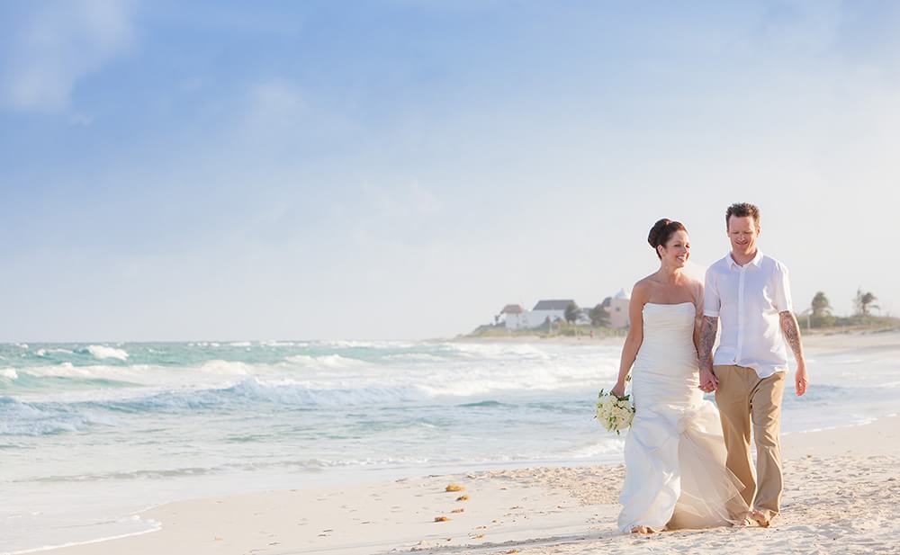 Wedding couple walking down beach in Riviera Maya