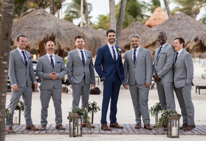 Groom at a Beach Wedding following a styling tip to wear a dark suit to stand out from other groomsmen.