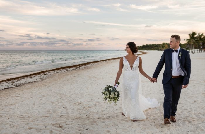Bride and groom walking on the beach in the Riviera Maya