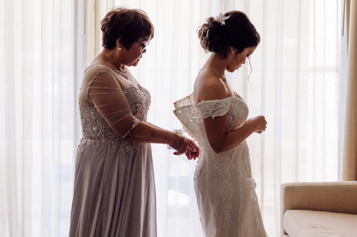 Mother helping bride with dress at wedding in Mexico