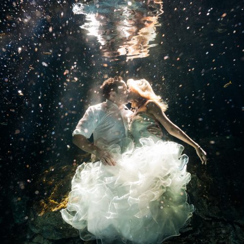 Bride and groom kissing in underwater trash the dress in Mayan Cenote at Riviera Maya