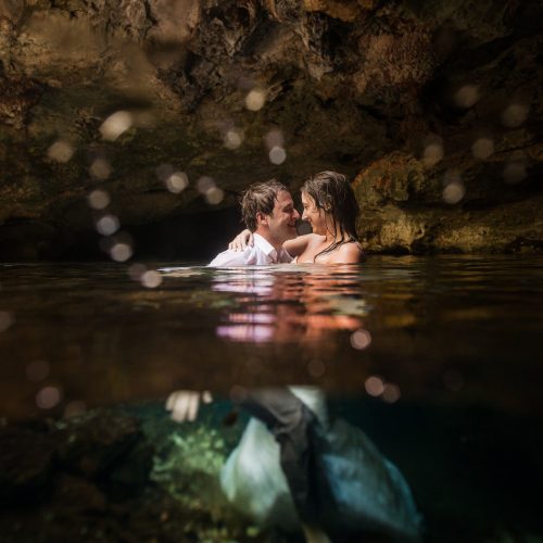 Half underwater photography of groom and Bride in Mayan Cenote at Riviera Maya