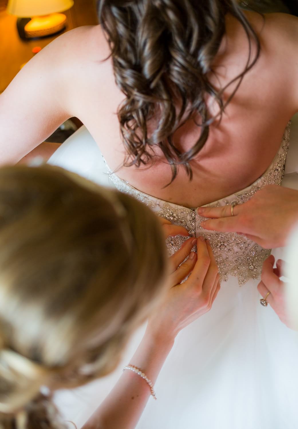 Detail of bride getting into dress.