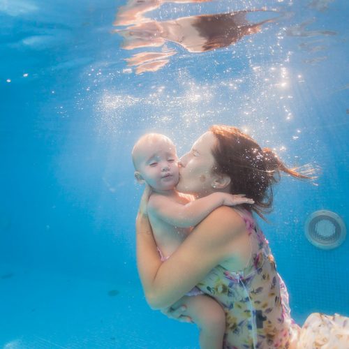 Baby underwater with mother in Mexico