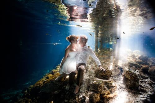 Couple underwater in Mayan Cenote trash the dress