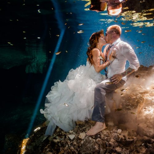 Bride and groom kissing underwater in Mayan cenote Trash the Dress session