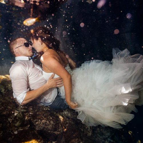 Bride and groom laying down underwater in Mayan cenote Trash the Dress session