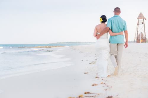 Amy and David walking down the beach at their Destination Beach Wedding at Iberostar Lindo Mexico