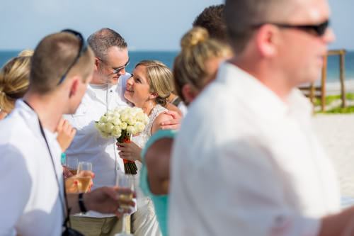 Family hug on a beach wedding at Ocean Coral and Turquesa