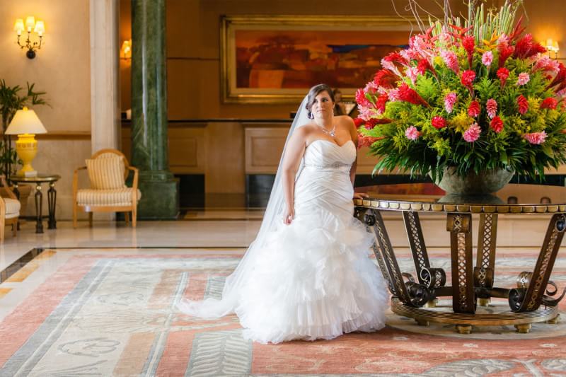 Plus sized bride wearing wedding dress in lobby of hotel