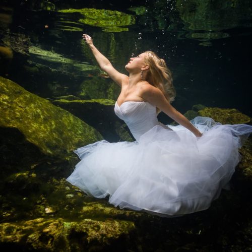 bride swimming in underwater trash the dress in Mayan Cenote at Riviera Maya