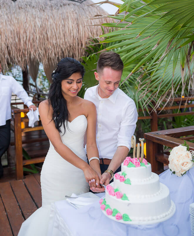 Bride and groom cutting wedding cake.