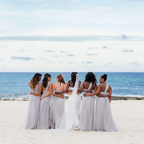 Bridesmaids arm in arm after wedding at Iberostar Grand Hotel Paraiso