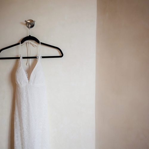 Wedding dress hanging on wall.