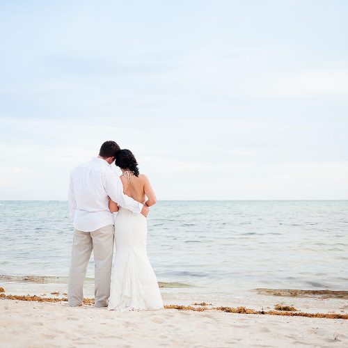 Bride and groom looking out at ocean in Tulum