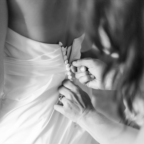 Close up of brides dress being zipped up at Excellence Playa Mujeres wedding.