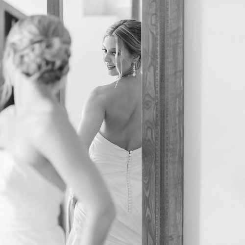 Bride looking at herself in mirror before wedding at Excellence Playa Mujeres