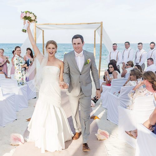 Bride and groom celebrate after wedding atExcellence Playa Mujeres