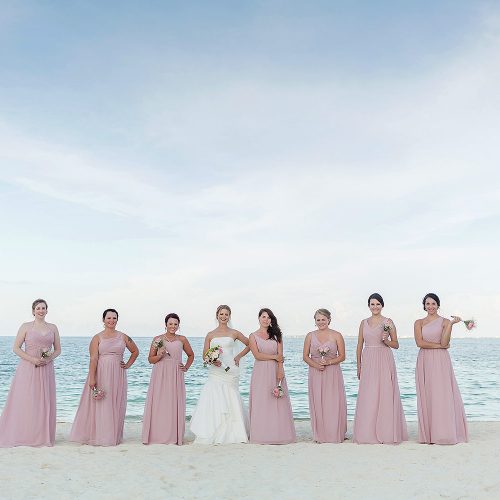 Bridesmaids on beach with ocean in background at Excellence Playa Mujeres