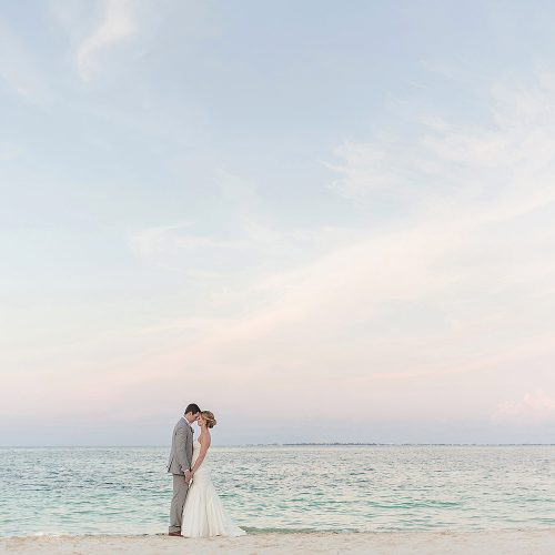 Bride and groom on beach at Excellence Playa Mujeres