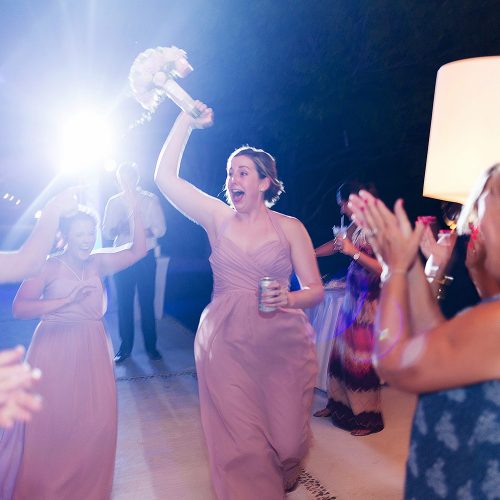 Bridesmaid catching bouquet at wedding reception.