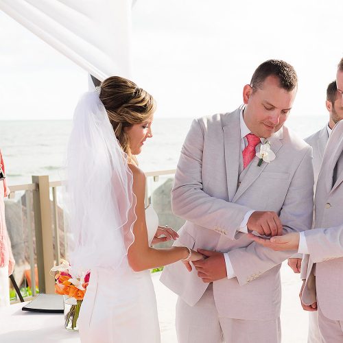 Groom putting on brides ring at pergola wedding location at NOW Jade Riviera Cancun wedding