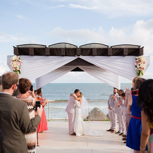Bride and groom kiss under the pergola at Gazebo wedding location at NOW Jade Riviera Cancun