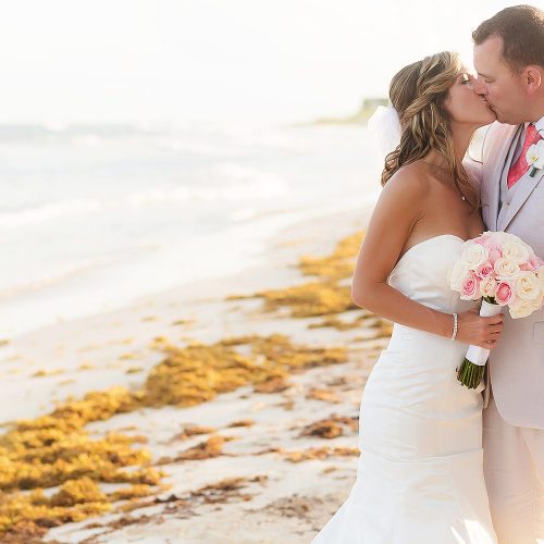 Bride and groom kissing on beach at NOW Jade Riviera Cancun wedding