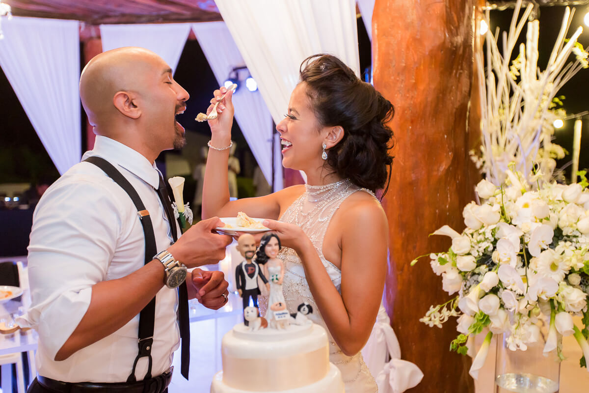 Bride feeding the groom cake at wedding reception