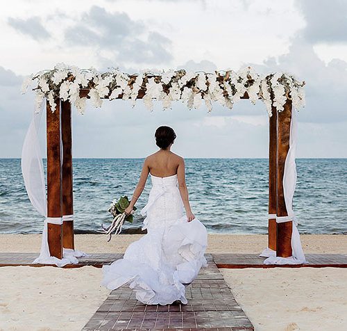 Bride running on beach in Cancun