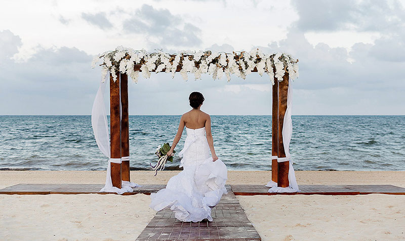 Bride running on beach in Cancun