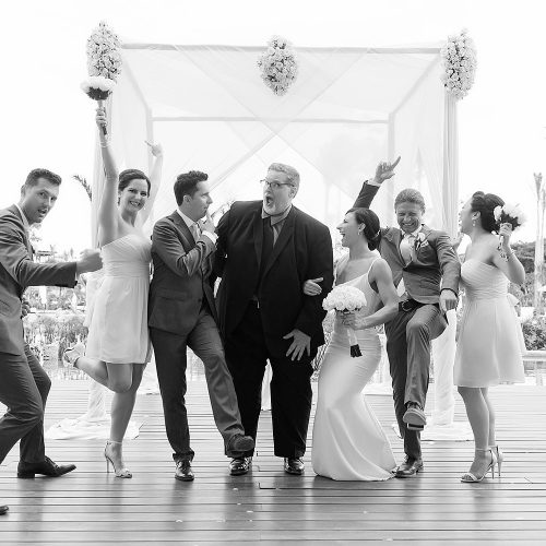 Bridal party with minister having fun after wedding