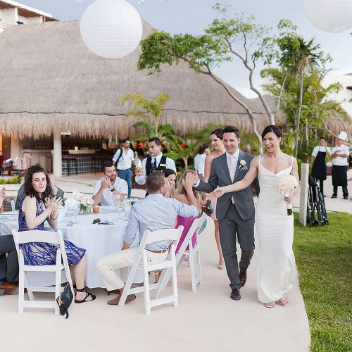 Bride and groom showing up to poolside reception at Secrets Akumal Riviera Maya wedding