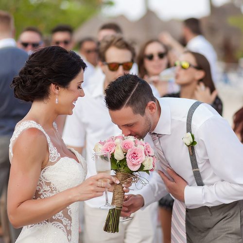 groom sniffing flowers bouquet at Playa del Carmen Wedding