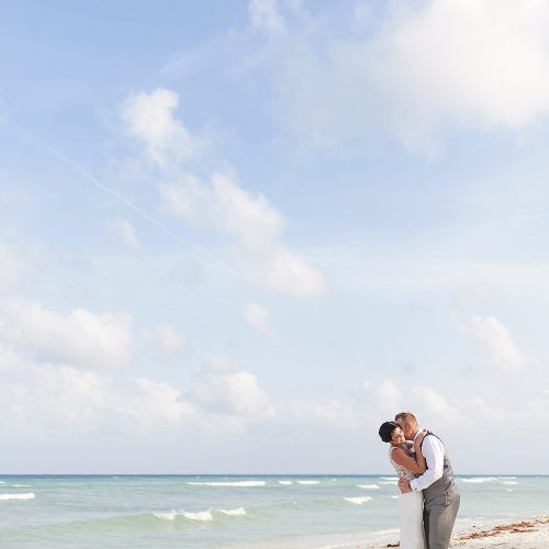 Bride and groom kissing on the beach at Riviera Maya