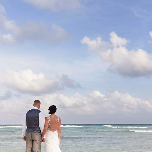 Bride and groom on the beach looking at the ocean at Playa del Carmen wedding
