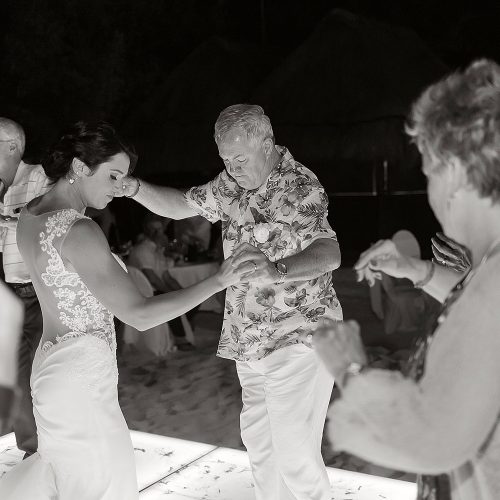 black and white photography of bride and father having fun at Playa del Carmen wedding reception