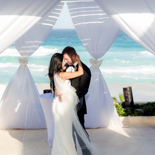 Bride and grooms first kiss at Secrets The Vine Cancun wedding