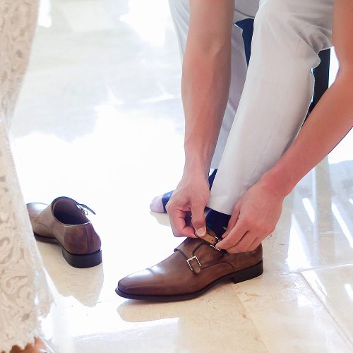 Groom doing up shoes at Live Aqua Cancun wedding