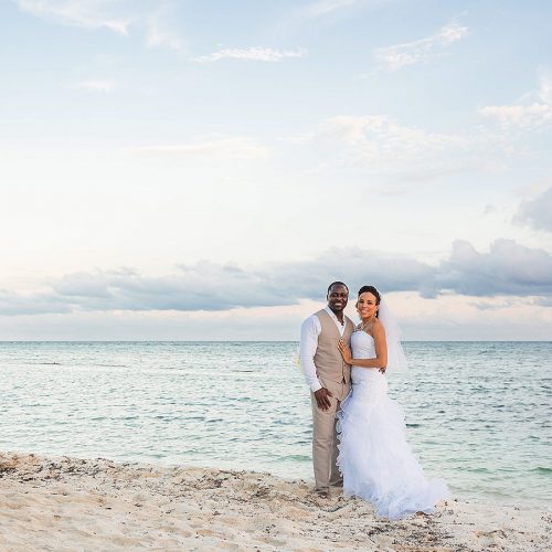 Portait of bride and groom on beach at El Dorado Seaside Suites