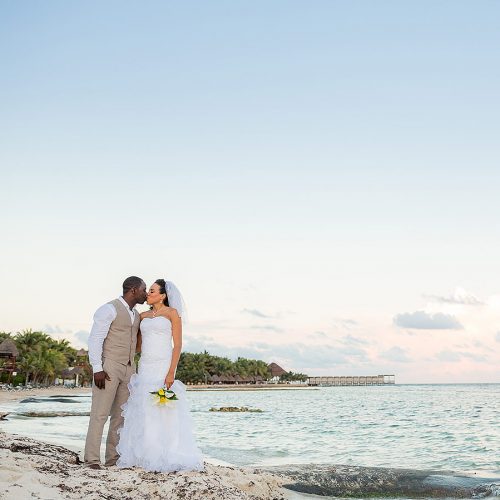 Portrait of bride and groom on beach at El Dorado Seaside Suites