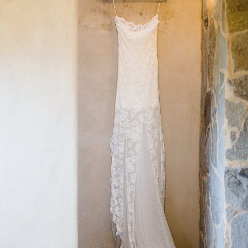 Wedding dress hanging on wall.