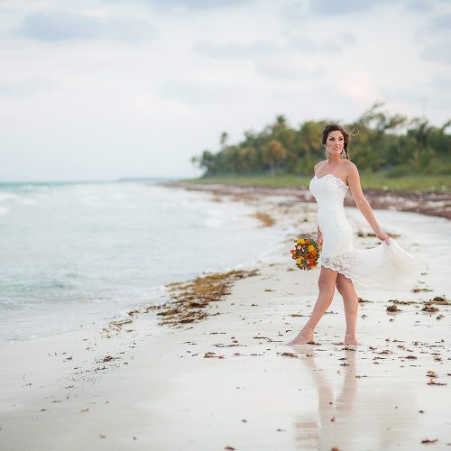 Bride on beach in Tulum after wedding.