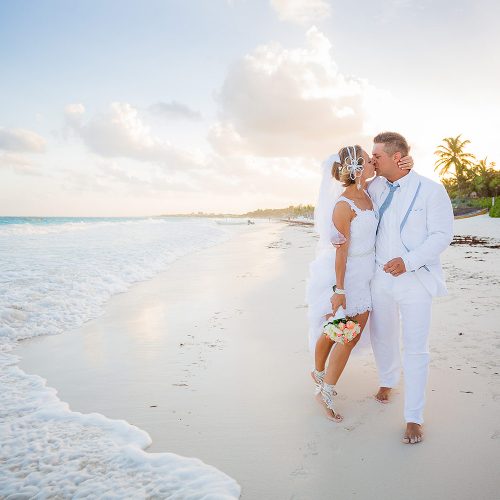 Bride and groom kissing on beach in Tulum