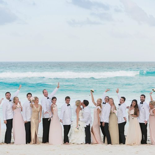 Bridal party cheering at groom and bride at Hard Rock Cancun beach wedding