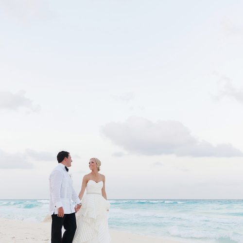 groom and bride walking on the beach at Hard Rock Cancun
