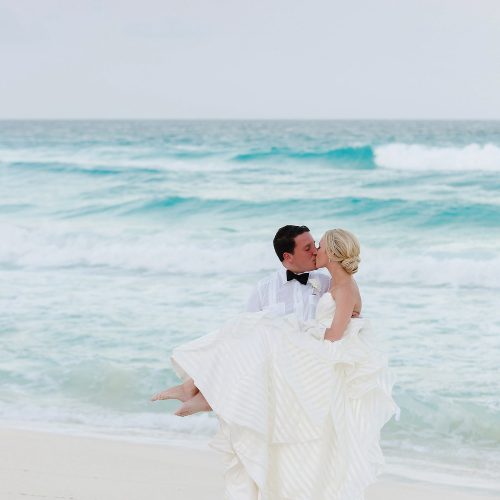 Groom carrying bride at Hard Rock Cancun beach wedding