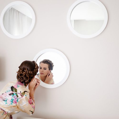 Bride looking in mirror getting ready at Azul Fives Hotel, Riviera Maya