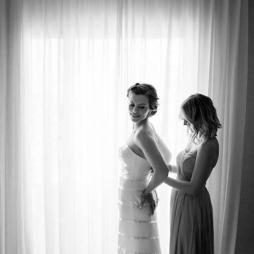 Bride and bridesmaid putting on dress at Azul Fives Hotel, Riviera Maya