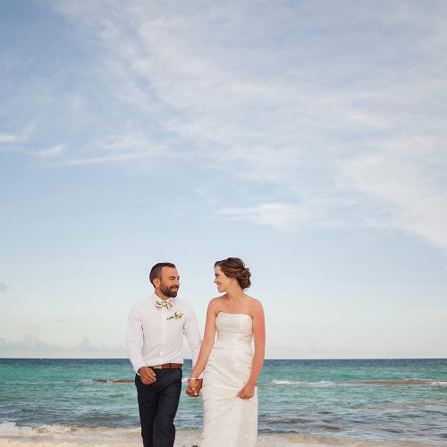 Bride and groom walking on beach at Azul Fives Hotel, Riviera Maya